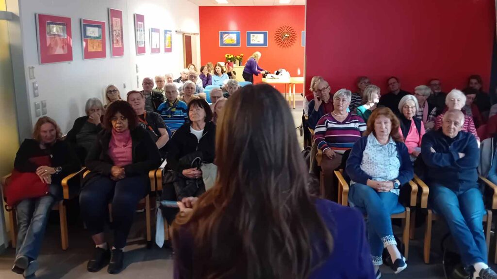 Tiny von deaex hält im Seniorenmonat 2025 einen Vortrag, Photo von hinten über die Gruppe