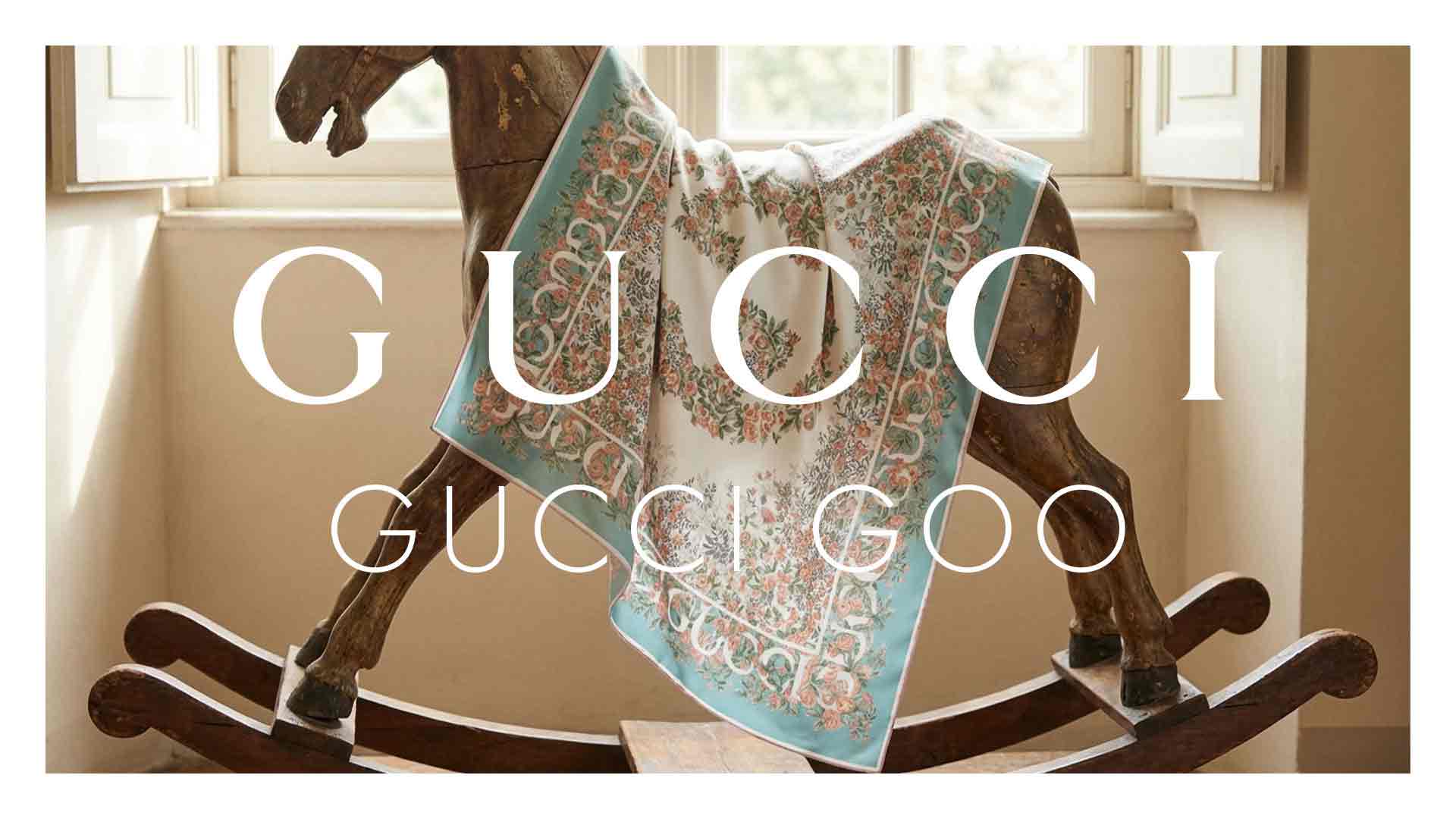 Gucci fashion banner showing a pastel floral scarf draped over a wooden rocking horse in a sunlit room
